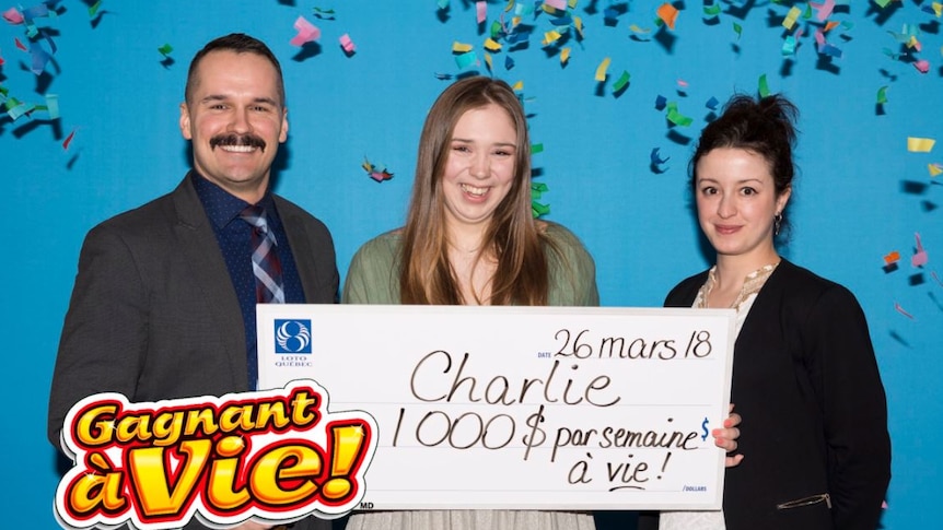 Charlie Lagarde holds up her 1,000 cheque from Loto Quebec