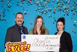 Charlie Lagarde holds up her 1,000 cheque from Loto Quebec