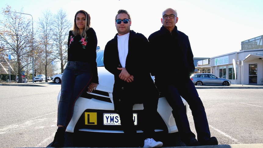 Driving instructor Greg Narrier and his students Harold Connors and Karteorah McBride standing in front of an L-plate car.