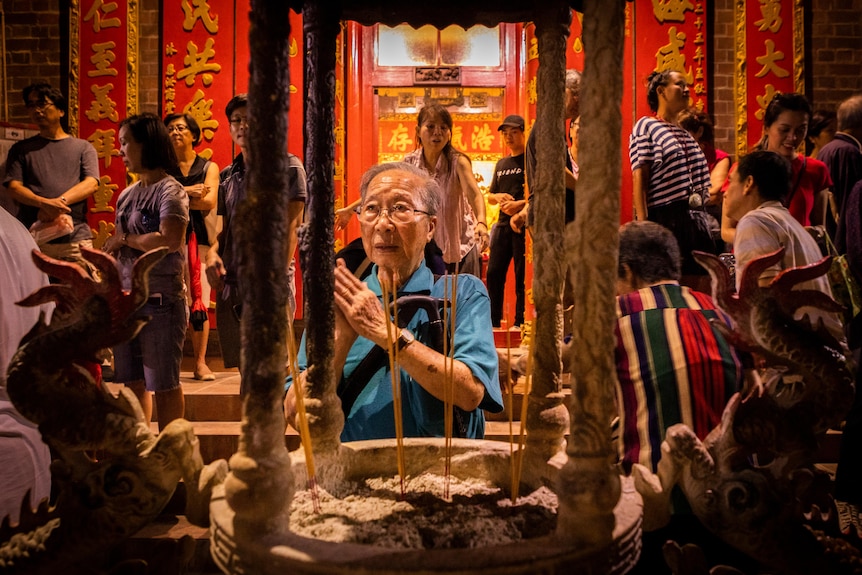 A woman in glasses and blue shirt at a temple 