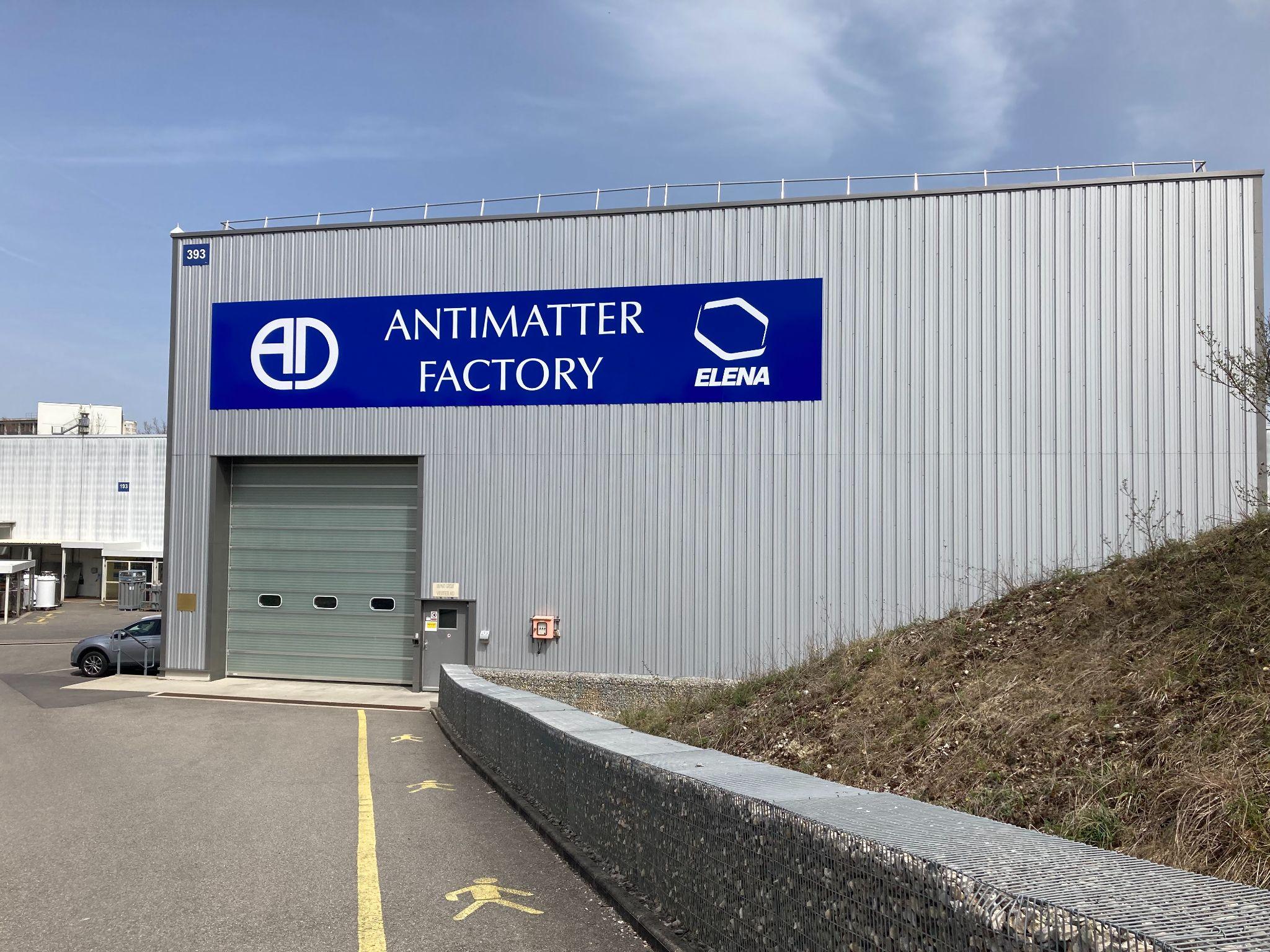 A large warehouse structure with a big blue sign saying 'Antimatter Factory'