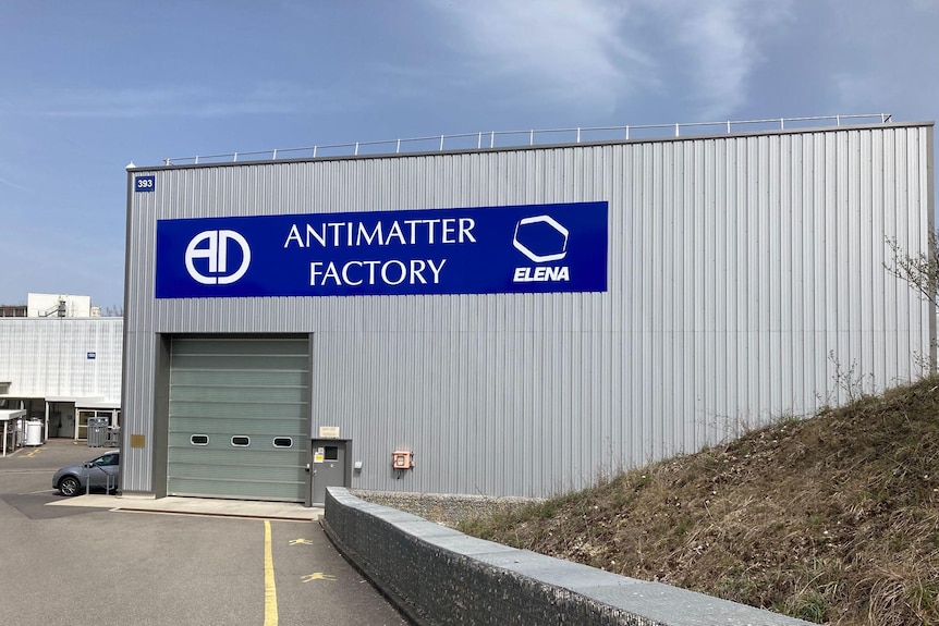 A large warehouse structure with a big blue sign saying 'Antimatter Factory'