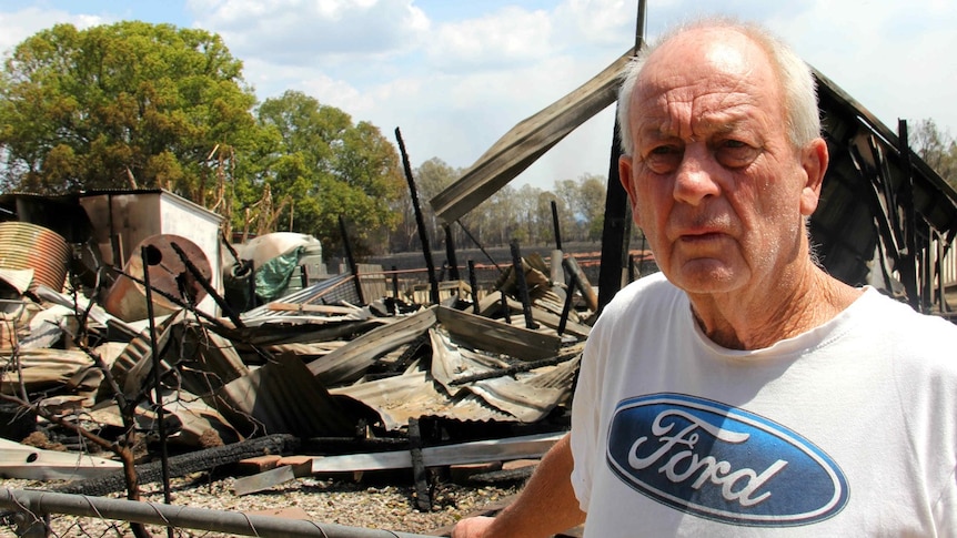 A man in front a destroyed house.