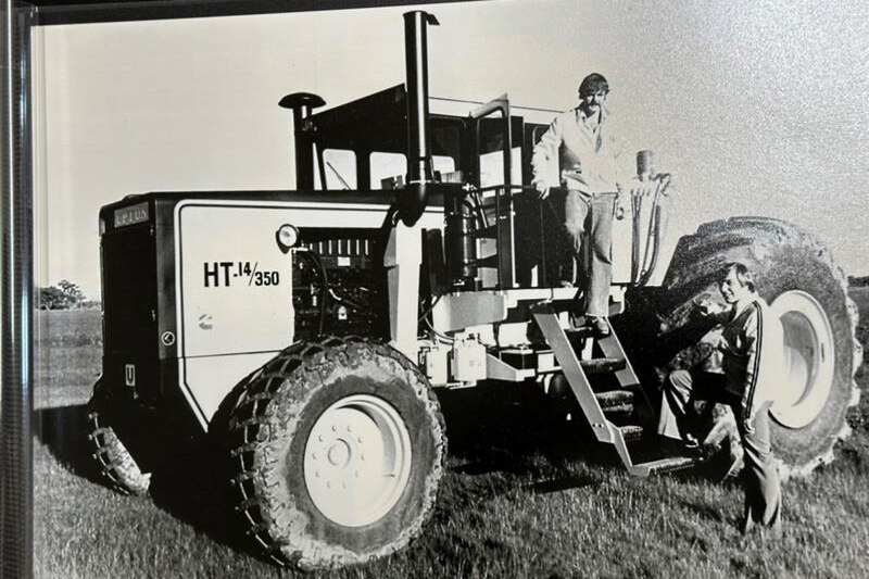 Black and white image of a man with a tractor.