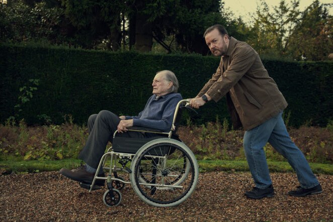 Ricky Gervais as Tony pushes his father in a wheelchair