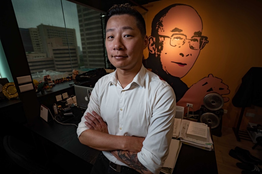 Taiwanese death metal rocker Freddy Lim in an office with a Dalai Lama poster on the wall