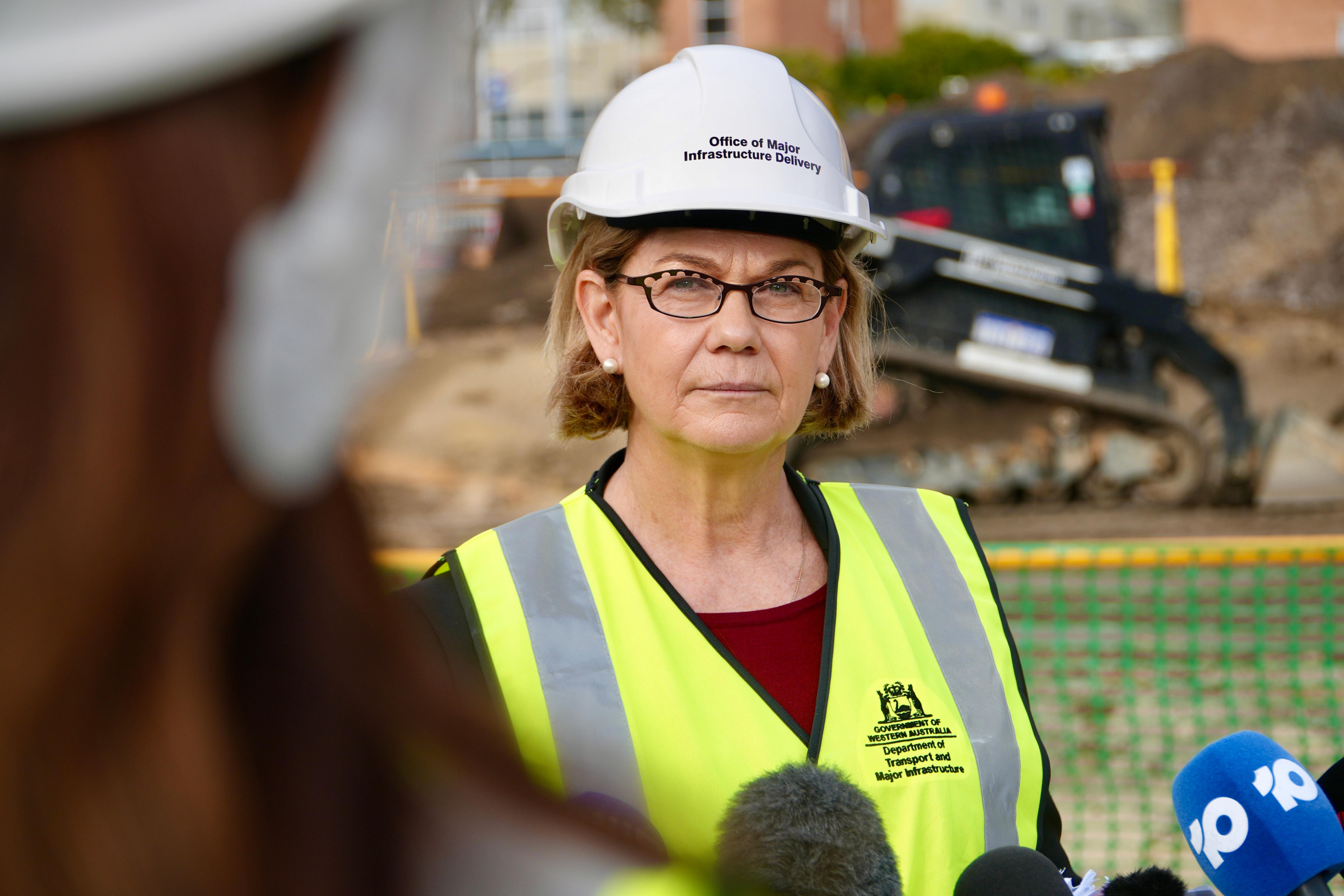 Meredith wears high vis and a hard hat on a construction site