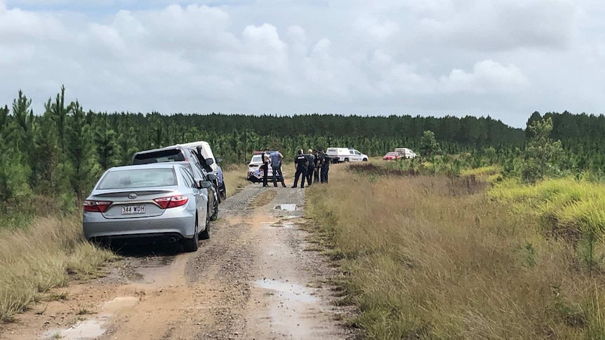 Police establish crime scene after the bodies of a man and a child are found in a red car at Coochin Creek camp grounds.