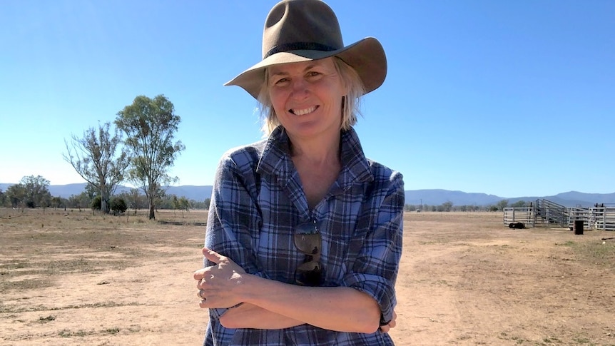 Shanna Whan, creator of the online platform Sober in the Country, wearing a hat and standing in a dusty paddock.