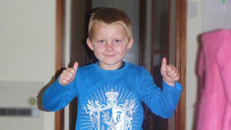 Bradyn Dillon gives the thumbs up while wearing a blue shirt with a white pattern on it