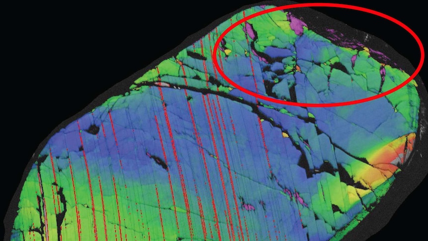 An electron diffraction image showing a piece of rock with a red circle highlighting areas of the rare mineral reidite.