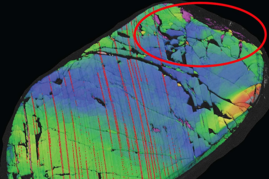 An electron diffraction image showing a piece of rock with a red circle highlighting areas of the rare mineral reidite.