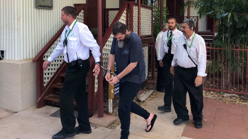 Image of a man being escorted by prison guards outside of the Broome Supreme Court.