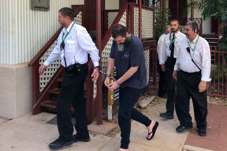 Image of a man being escorted by prison guards outside of the Broome Supreme Court.