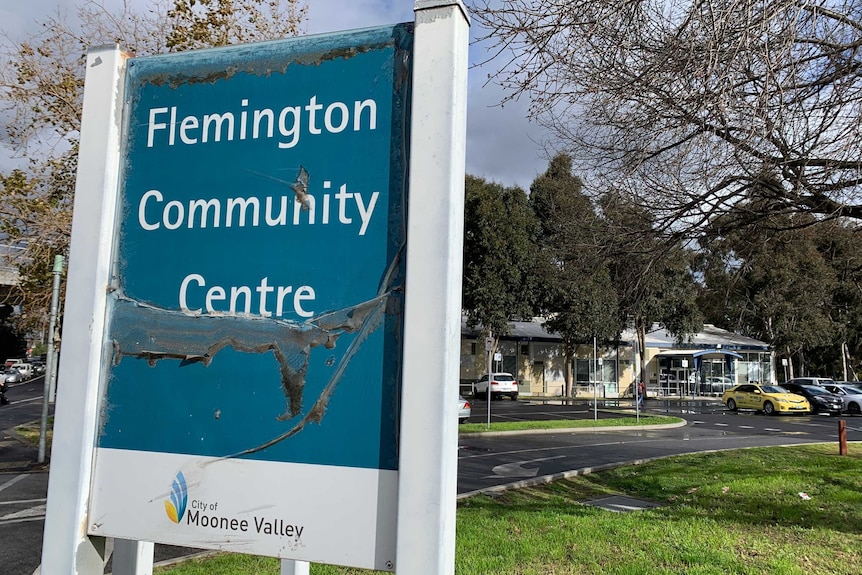 A worn out blue sign for the Flemington Community Centre outside the centre.