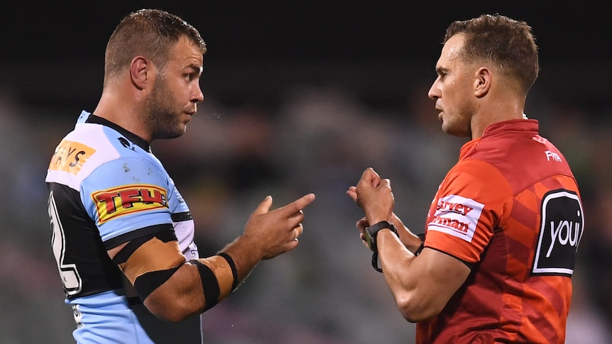 A football player talks with a referee