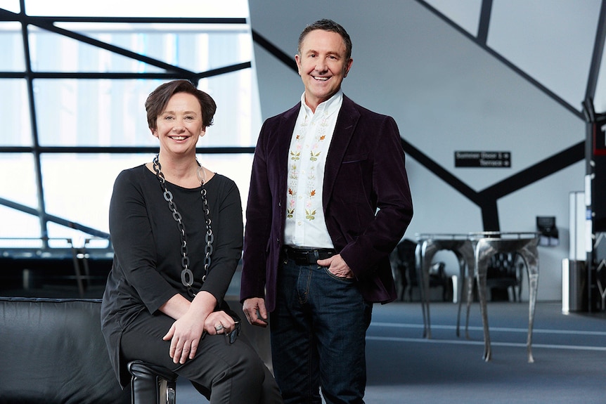 Colour photo of Virginia Lovetts sitting on arm of couch and Brett Sheehy AO standing in foyer at Melbourne Theatre Company.