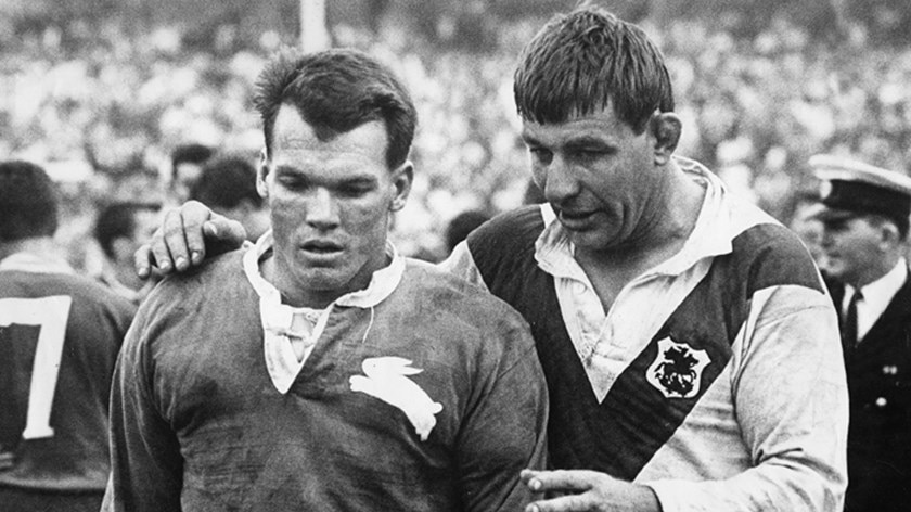 A black and white photo of Brian James on the football field with a St George player.