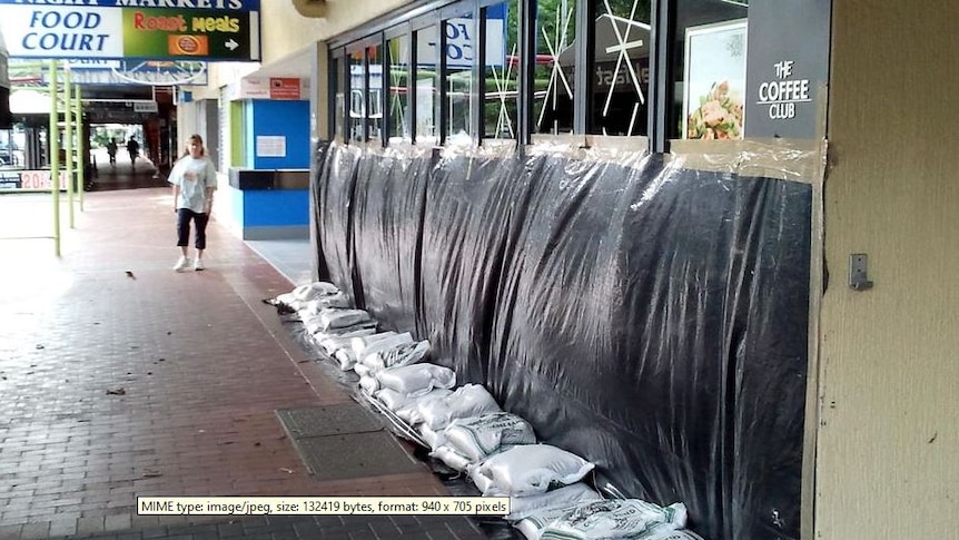 A shopfront in Cairns in Far North Queensland sandbagged and covered up with black plastic.