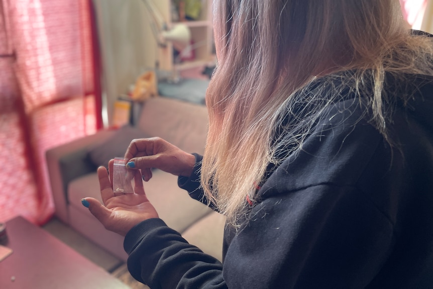 An unidentifiable woman holding a bag on heroin.