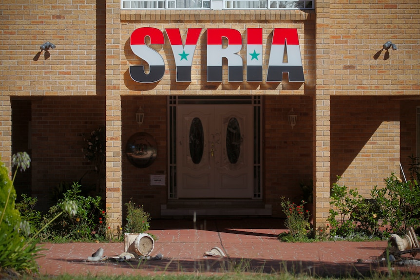 Broken windows and pot plants lie outside the Syrian Embassy in Canberra.