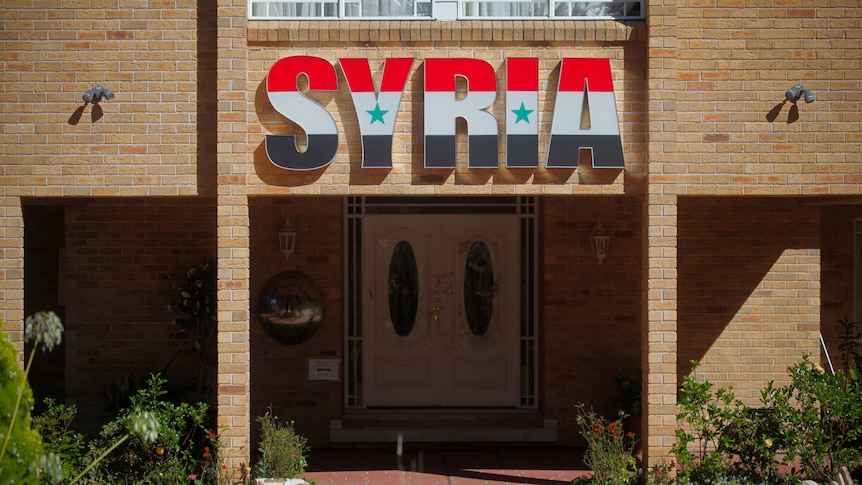 Broken windows and pot plants lie outside the Syrian Embassy in Canberra.