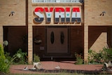 Broken windows and pot plants lie outside the Syrian Embassy in Canberra.