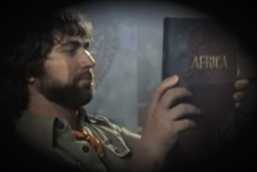 One of the guys from Toto holds up a book titled Africa