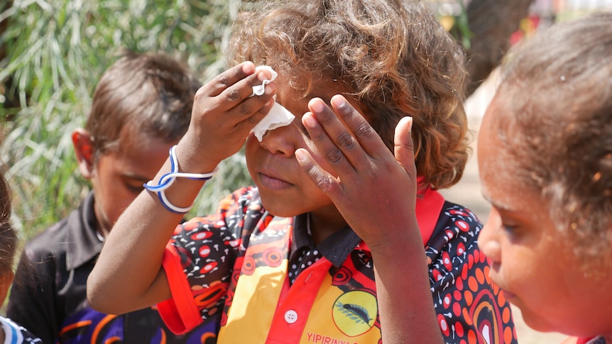 A student at Yipirinya School wiping his eye.