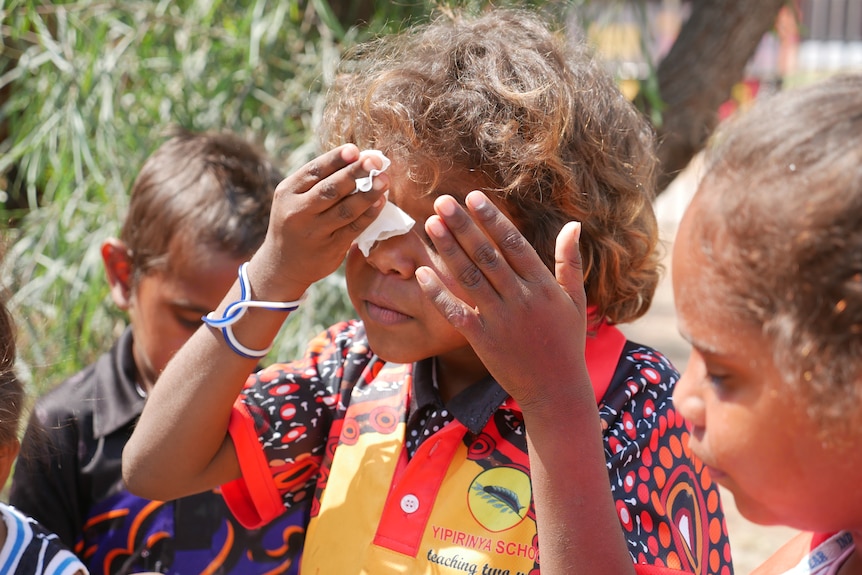 A student at Yipirinya School wiping his eye.
