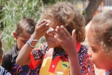 A student at Yipirinya School wiping his eye.