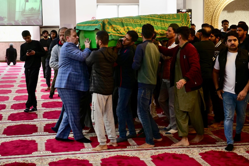 A group of people holding a coffin on their shoulders