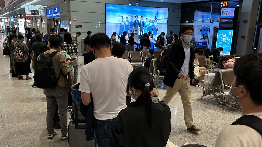 People line up to board a flight at a Chinese airport.