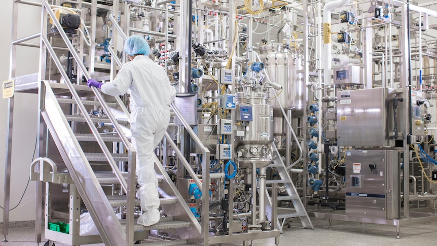 A person in full PPE walks up a processing staircase.