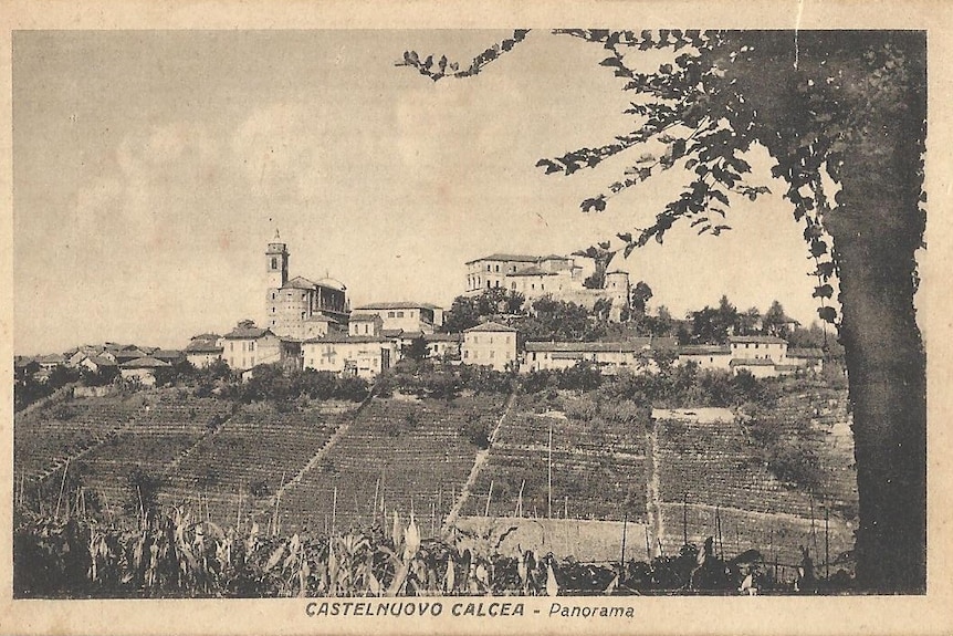 A black and white photograph of a picturesque Italian village built on a hill. 