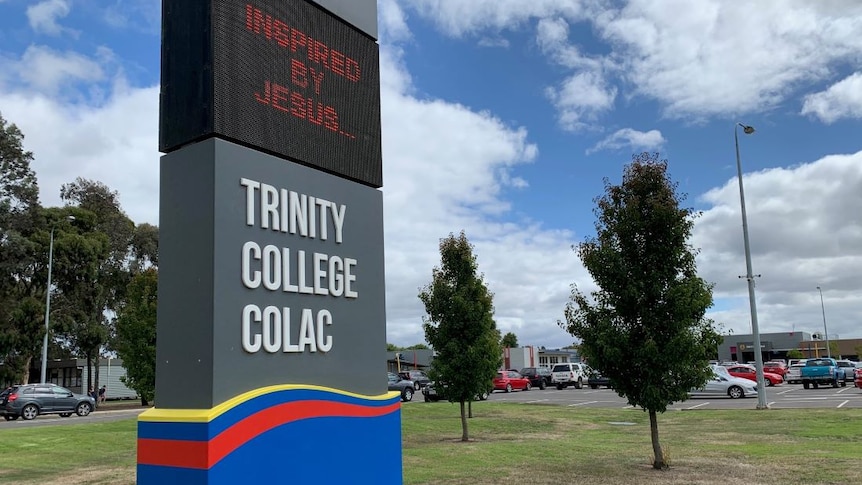A large sign out the front of a school grounds says Trinity College Colac with a digital display that says Inspired By Jesus.