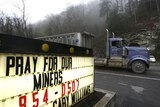 A truck drives past a sign reading near the Upper Big Branch Mine