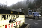 A truck drives past a sign reading near the Upper Big Branch Mine