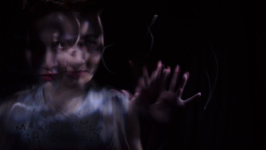 Multiple exposure photo of a woman with two images overlayed against a black background