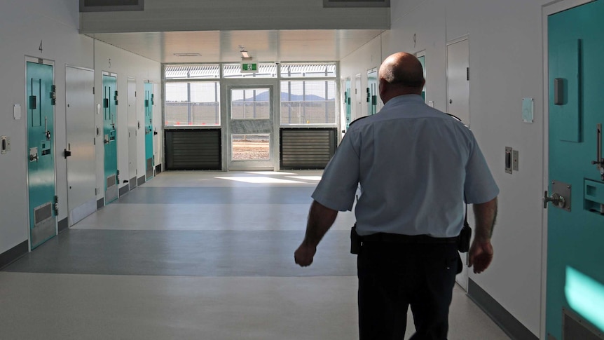 Prison guard in corridor of Special Care Unit at the Alexander Maconochie Centre (AMC) in Hume.