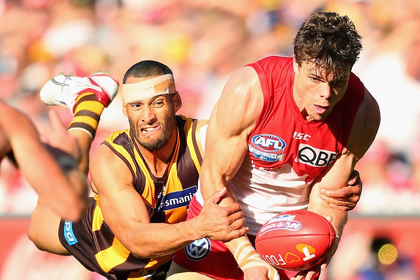 Hawthorn's Josh Gibson chases down Sydney's Mike Pyke in the 2014 AFL grand final.