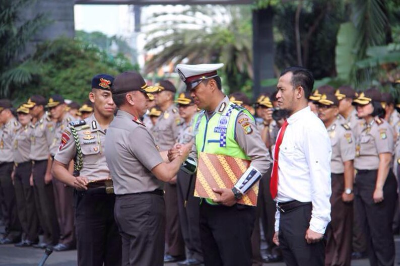 Indonesian traffic policeman Sunaryanto receives a bravery award from Jakarta police chief Muhammad Iriawan.