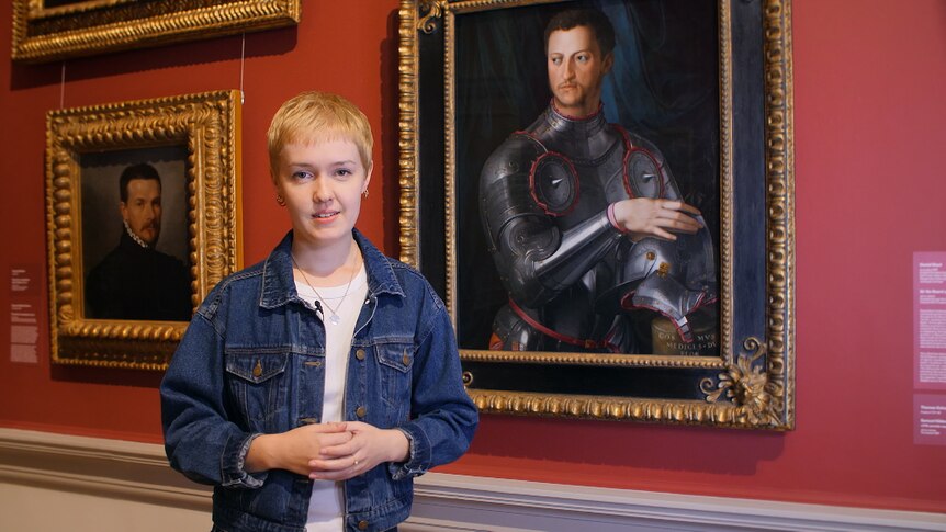 Mary McGillivray stands in front of painting of Cosimo Di Medici