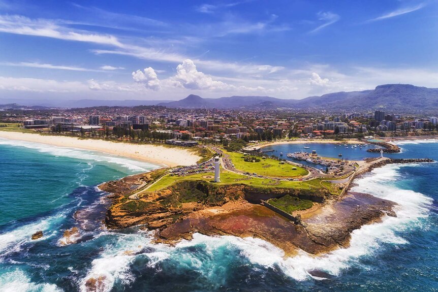 Aerial shot of Flagstaff Point lighthouse and breakwater with Wollongong city in the background.