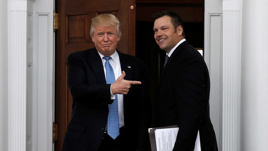 Donald Trump points at Kris Kobach at the door into the White House