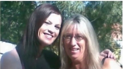 Two ladies wearing black standing together posing for a photo.