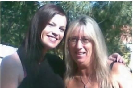 Two ladies wearing black standing together posing for a photo