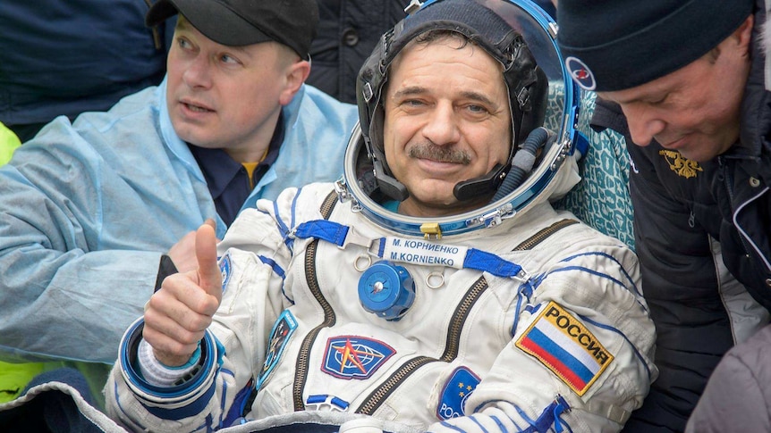 Cosmonaut in his space suit after landing giving thumbs up
