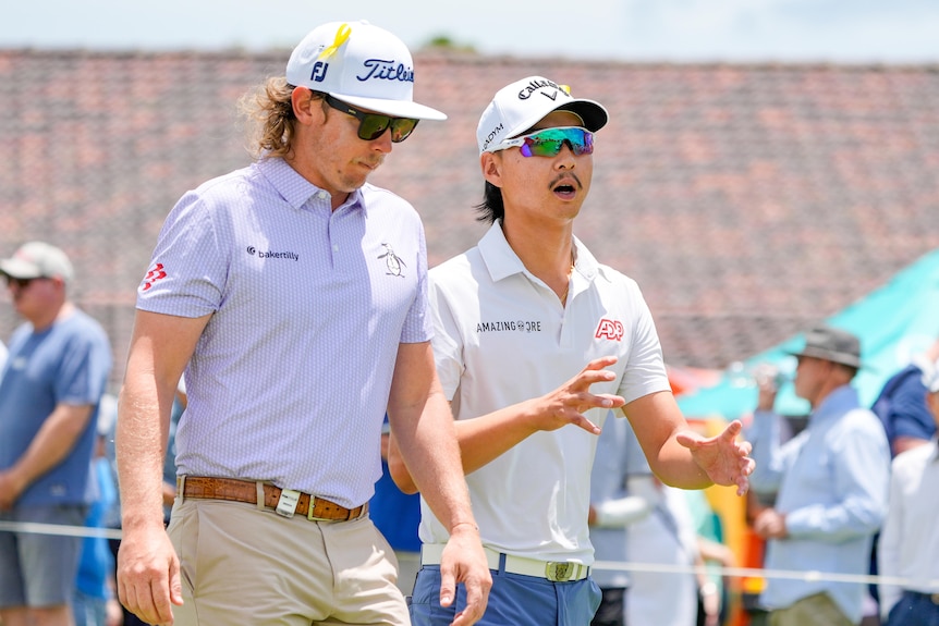 Min Woo Lee speaks to Cameron Smith as they walk the course at the Australian PGA Championship golf tournament.