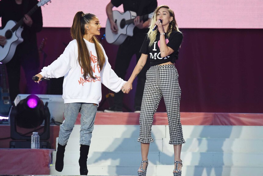 Singers Ariana Grande, left, and Miley Cyrus perform at the One Love Manchester tribute concert